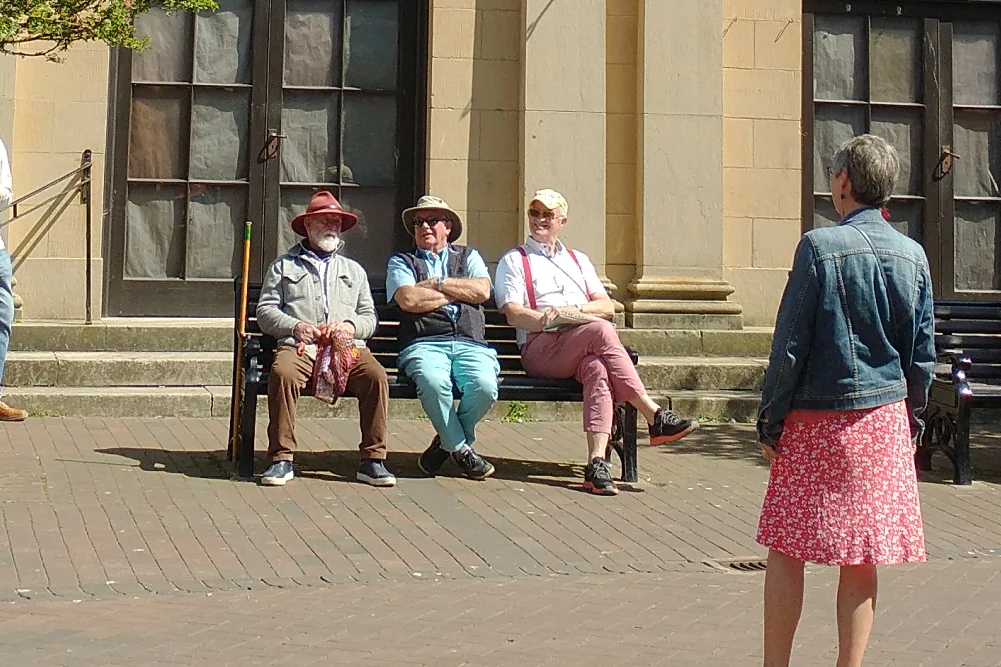 Locals chatting on a bench in a Devon seaside town
